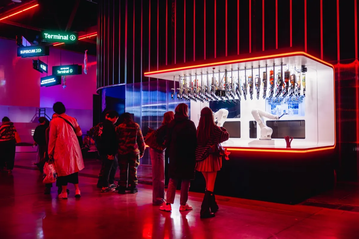 Des visiteurs font la queue au bar robotisé de Time Mission Bruxelles